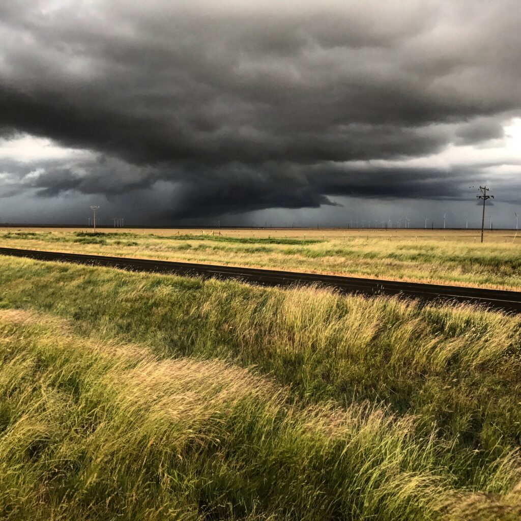 a photograph of a thunderstorm over a field.