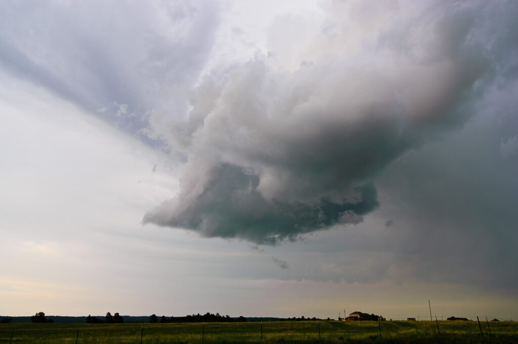 A photograph of a rotating thunderstorm over a field.