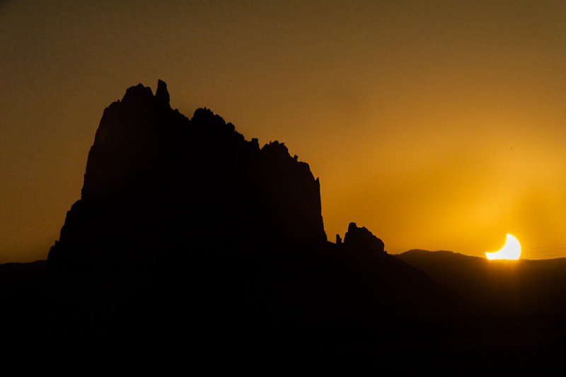 A photograph of rock formations in front of a sunset.