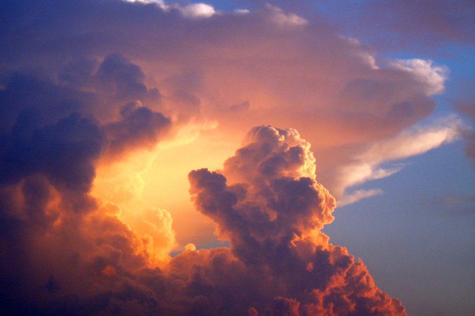 An image of Cumulus clouds rising in the sky of the setting sun.