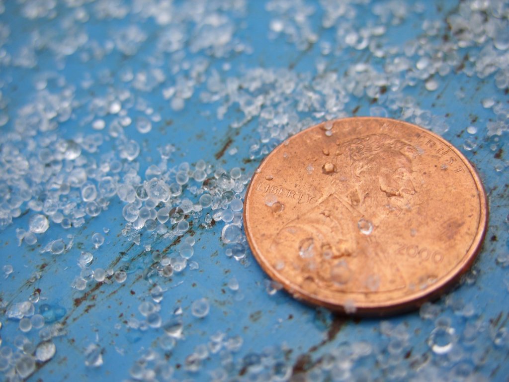 Ice pellets next to a U.S. penny (19.05 mm diameter) for scale