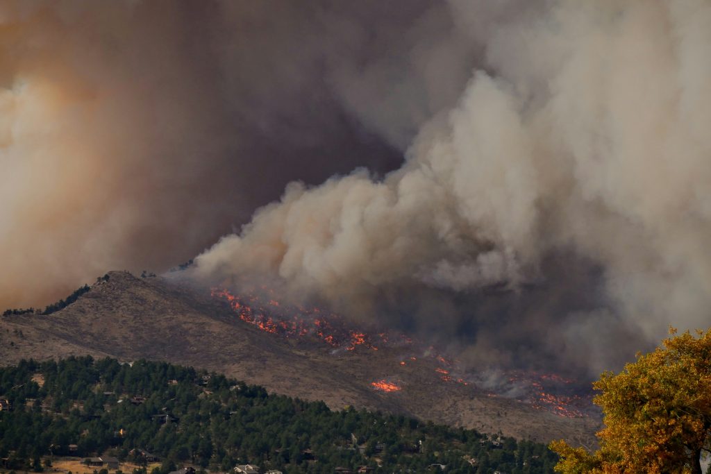 A photograph of the Calwood Wildfire and associated smoke plume over the mountains of Colorado. Photo Credit Malachi Brooks via Unsplash.