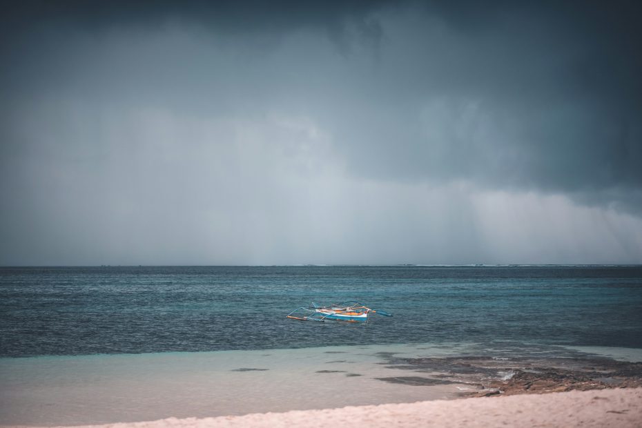 Boat in the ocean during a storm - photo by Jopeel Quimpo via Unsplash